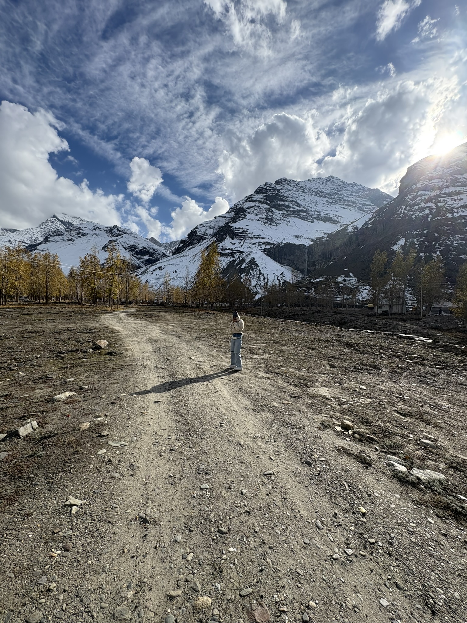 dirt road below snow mountains